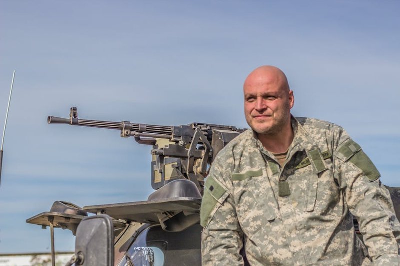Military personnel applying shell-based repellent technology in field conditions