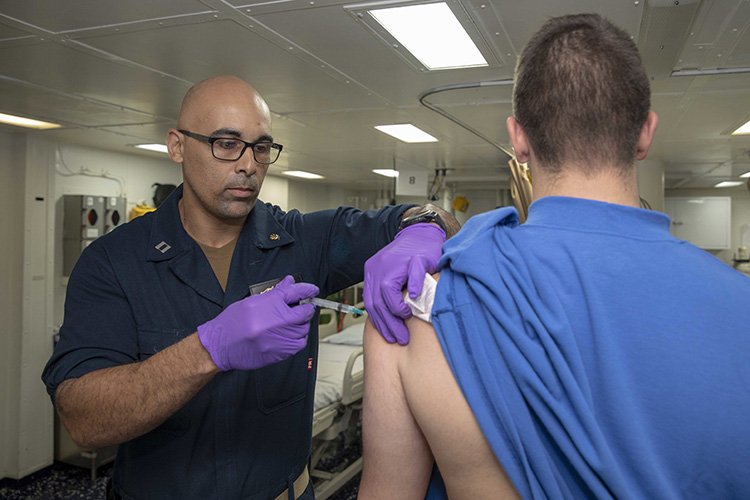 nurse using laser therapy device on patient wound