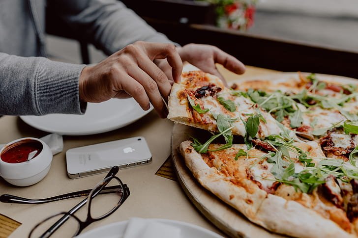 person enjoying food with smart device nearby